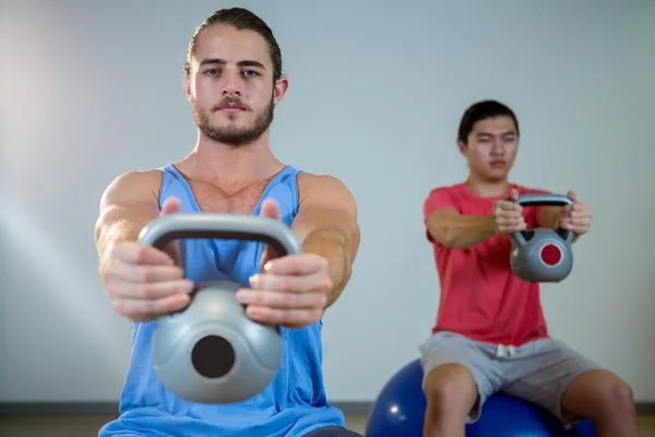 Hombres haciendo ejercicio sobre pelota de ejercicio — Foto de Stock