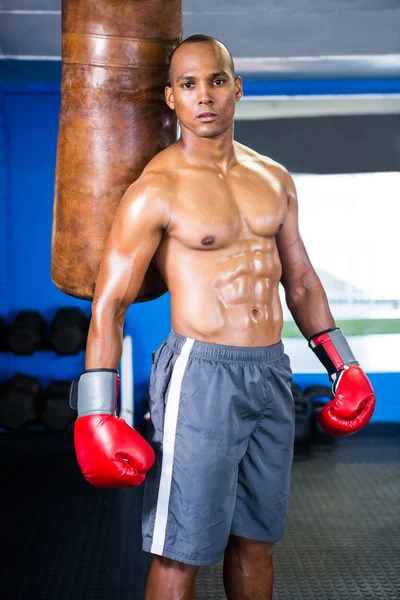 Boxeador masculino determinado de pie por saco de boxeo —  Fotos de Stock