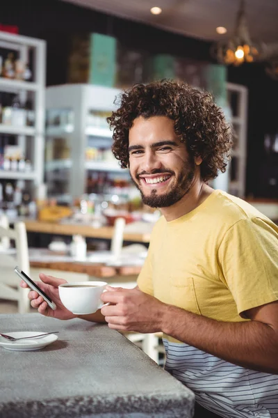 電話を押しながらコーヒーを飲んでいる人 — ストック写真