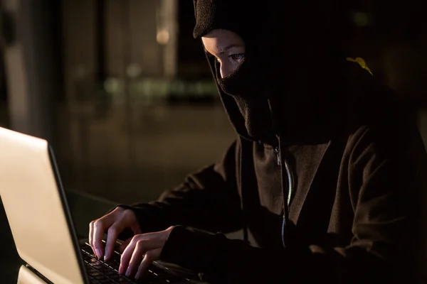 Kvinna i balaclava med laptop — Stockfoto