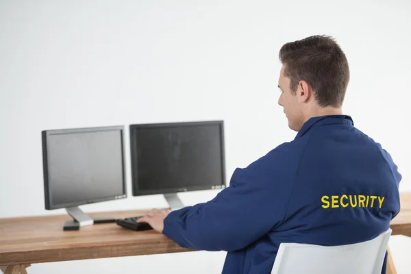Сотрудник службы безопасности с помощью компьютера — стоковое фото