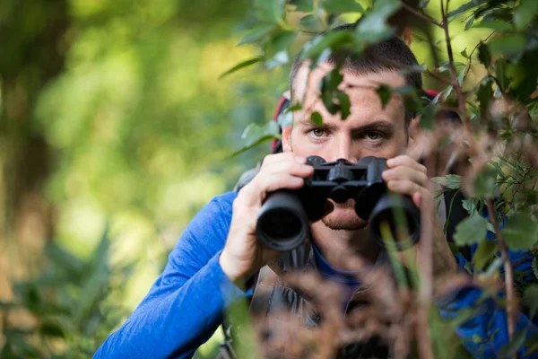 Escursionista maschio guardando attraverso il binocolo — Foto Stock
