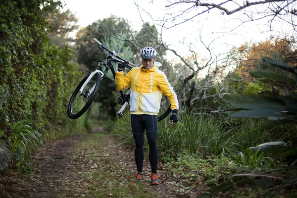 Motociclista masculino transportando bicicleta de montanha — Fotografia de Stock