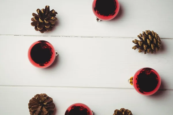 Bola roja de Navidad y cono de pino en la mesa —  Fotos de Stock