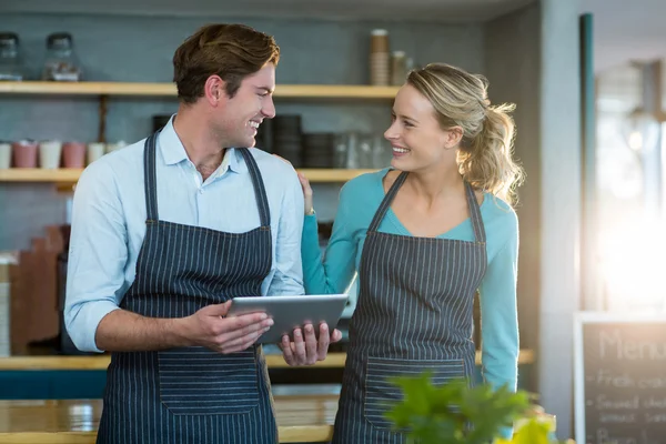 Kellner und Kellnerin interagieren mit Tablet — Stockfoto