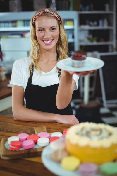 Waitress holding plate of cupcake — Stock Photo, Image