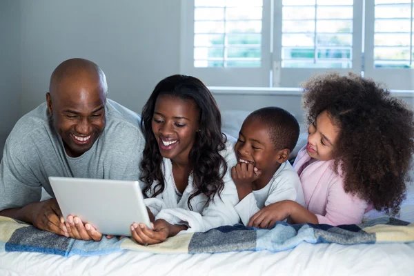Familie nutzt digitales Tablet auf dem Bett — Stockfoto