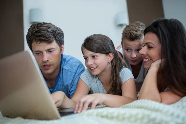 Happy family using laptop in bedroom — Stock Photo, Image