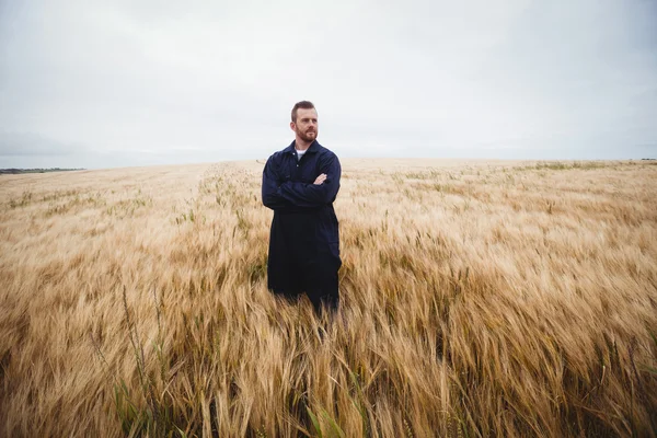 Agricultor de pie con los brazos cruzados en el campo — Foto de Stock