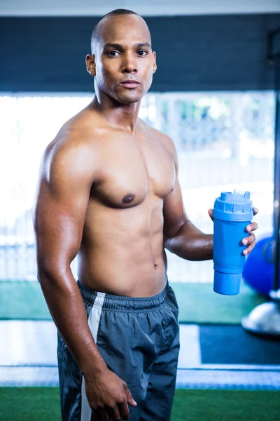 Muscular shirtless athlete holding bottle — Stock Photo, Image