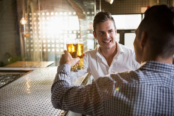 Dva muži opékání sklenici piva — Stock fotografie