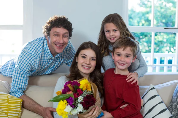 Família feliz com buquê de flores — Fotografia de Stock