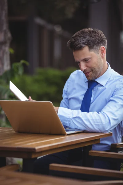 Knappe zakenman met laptop en tablet — Stockfoto