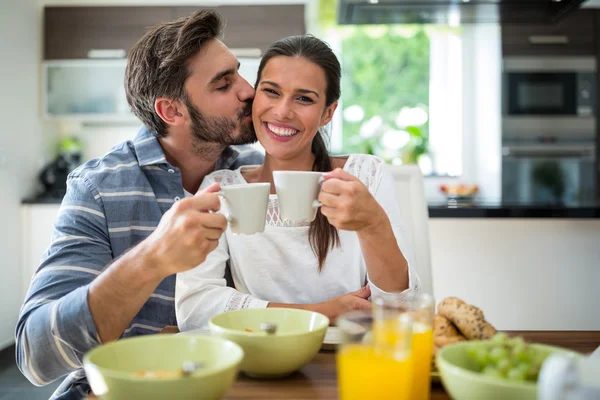 Mann küsst Frau beim Frühstück auf die Wangen — Stockfoto