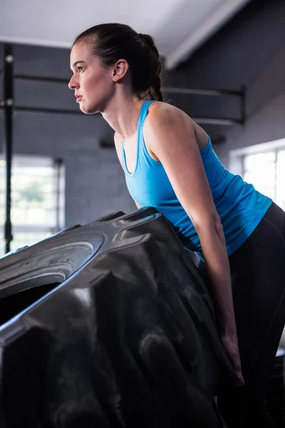 Kadın atlet lastik spor salonunda iterek — Stok fotoğraf