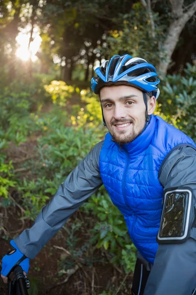 Чоловічий гірський велосипедист з велосипедом у лісі — стокове фото
