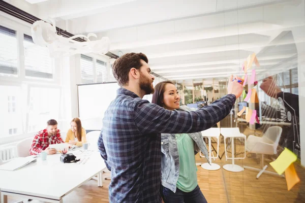 Gente de negocios mirando notas adhesivas — Foto de Stock