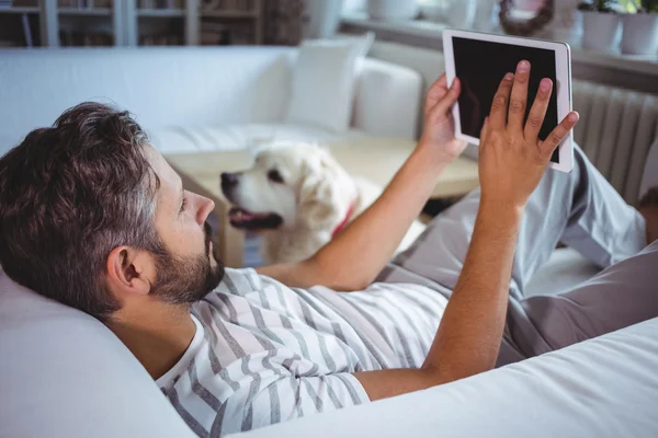 Uomo che utilizza tablet digitale in salotto — Foto Stock