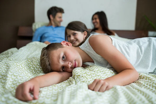 Familjen liggande på sängen i sovrummet — Stockfoto