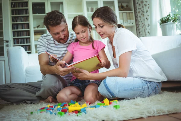 Eltern und Tochter lesen ein Buch — Stockfoto