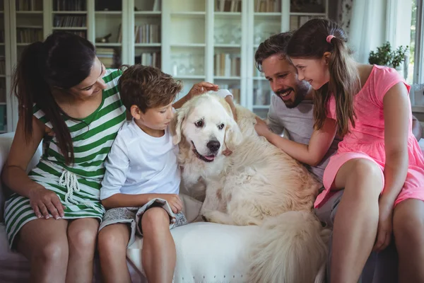 Famille assise sur canapé avec chien de compagnie — Photo