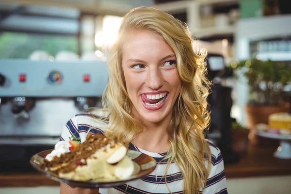 Kvinna anläggning tallrik desserter — Stockfoto