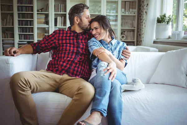 Hombre besar mujer mientras está sentado en sofá — Foto de Stock