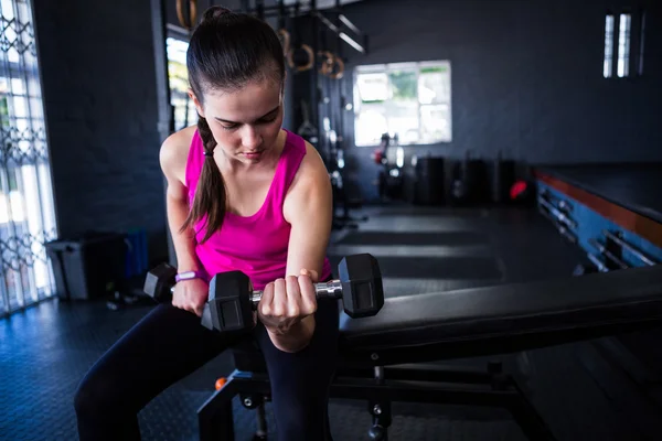 Vrouw bedrijf halters in sportschool — Stockfoto