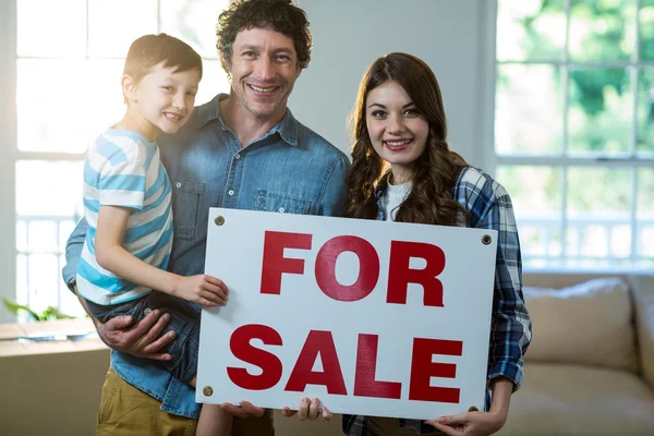 Couple standing and holding sold sign — Stock Photo, Image