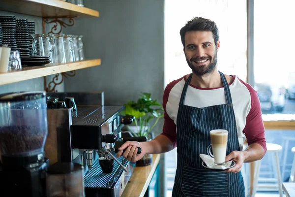 Camarero sosteniendo taza de café frío en el mostrador —  Fotos de Stock
