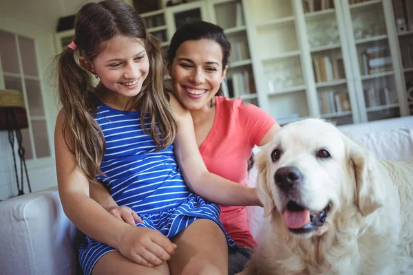 Anne ve kızı evde beslenen hayvan köpek ile oturan — Stok fotoğraf