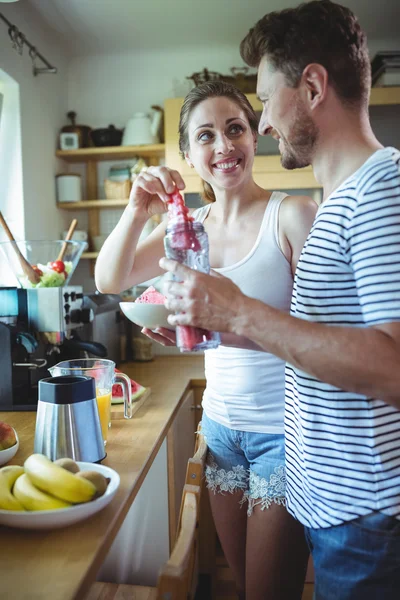 Couple preparing watermelon smoothie in kitchen — ストック写真