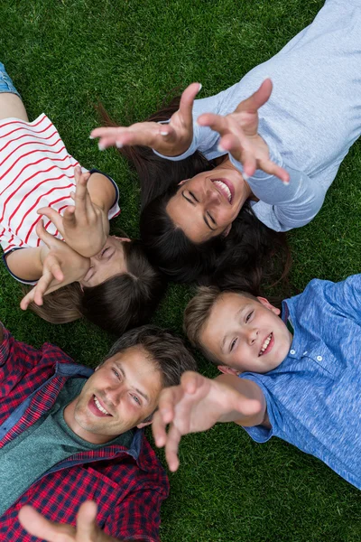 Gelukkige familie liggen op gras in park — Stockfoto