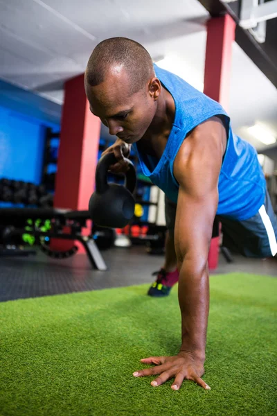 Young man holding kettlebell in gym — Stock Photo, Image