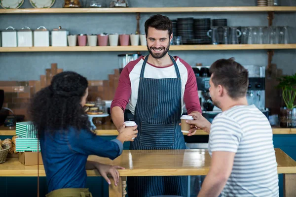 Waiter serving a coffee to customer — Stock Photo, Image