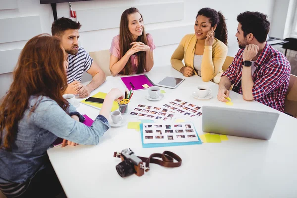 Editores discutindo fotografias em reunião — Fotografia de Stock