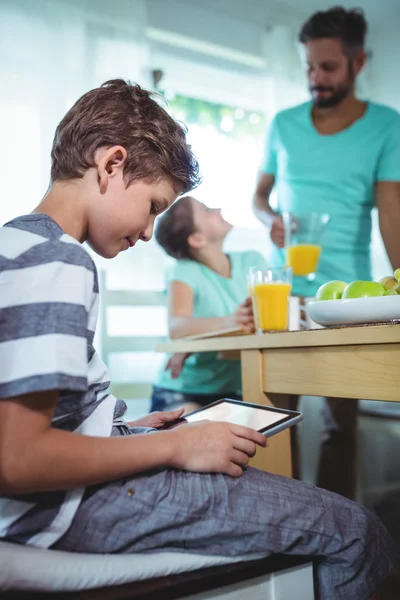 Jongen met behulp van digitale tablet met ontbijt op tafel — Stockfoto