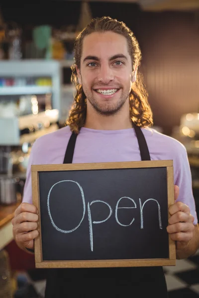 Camarero sosteniendo pizarra con cartel abierto — Foto de Stock