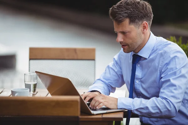 Knappe zakenman met behulp van laptop — Stockfoto