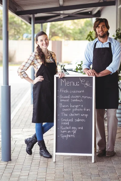 Serveur et serveuse debout avec panneau de menu — Photo