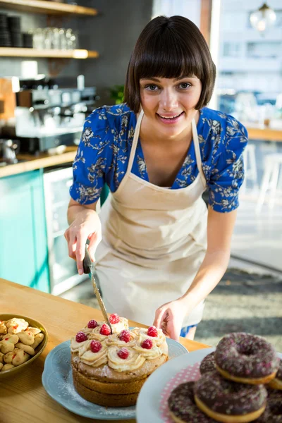 Pincérnő vágás torta kávézóban — Stock Fotó