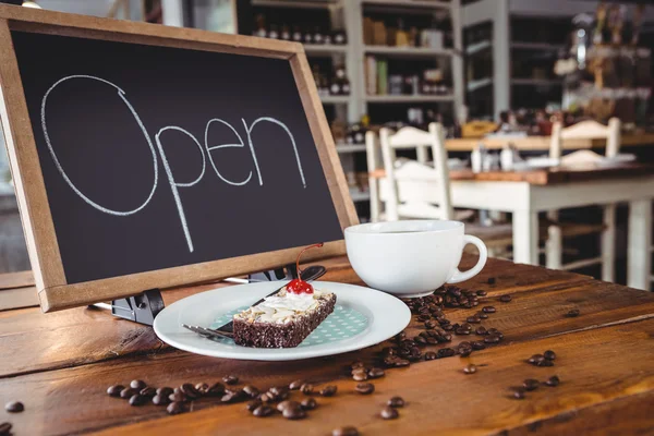 Öppna skylt med bit kaka och kaffe — Stockfoto