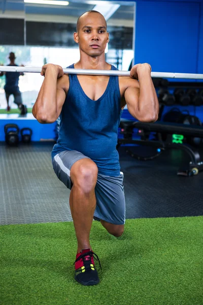 Homem levantando barra no estúdio de fitness — Fotografia de Stock