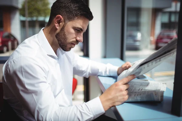 Hombre de negocios leyendo periódico en la oficina — Foto de Stock