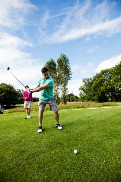 Instrutor masculino assistindo mulher na aprendizagem de golfe — Fotografia de Stock