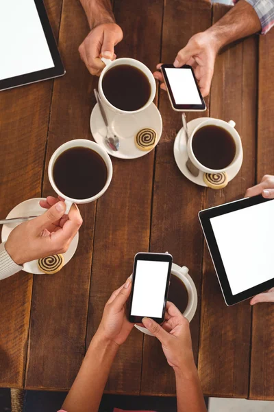 Amigos que usan teléfonos móviles mientras toman café —  Fotos de Stock