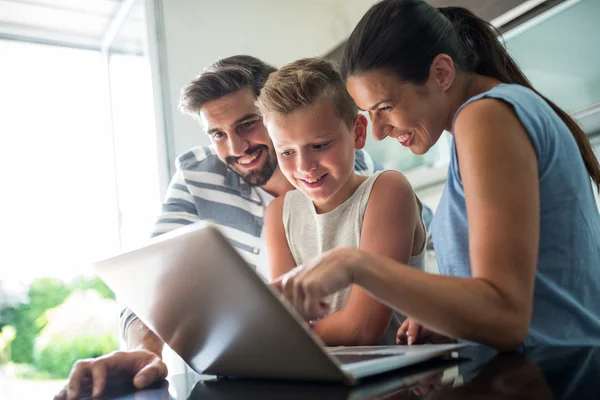 Familia feliz utilizando el ordenador portátil en la sala de estar — Foto de Stock