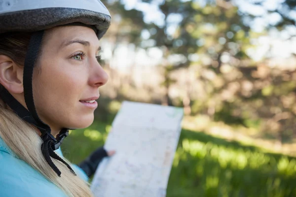 Mujer bicicleta de montaña sosteniendo mapa — Foto de Stock