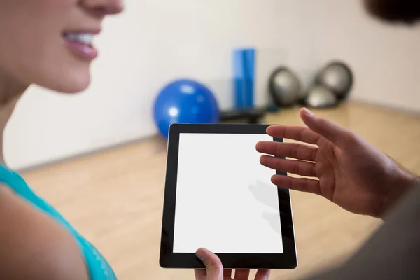 Fitnesstrainerin zeigt Frau Tablet — Stockfoto