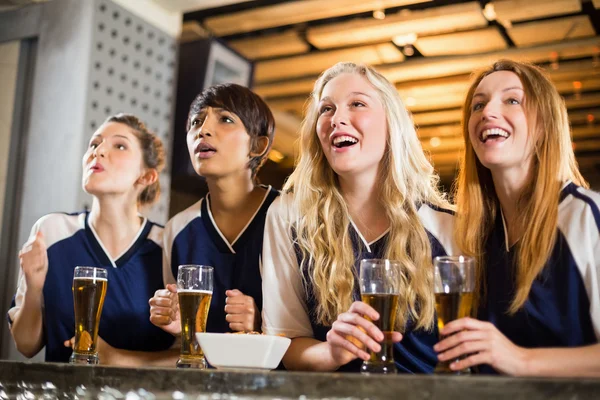 Fã feminina assistindo futebol no balcão do bar — Fotografia de Stock